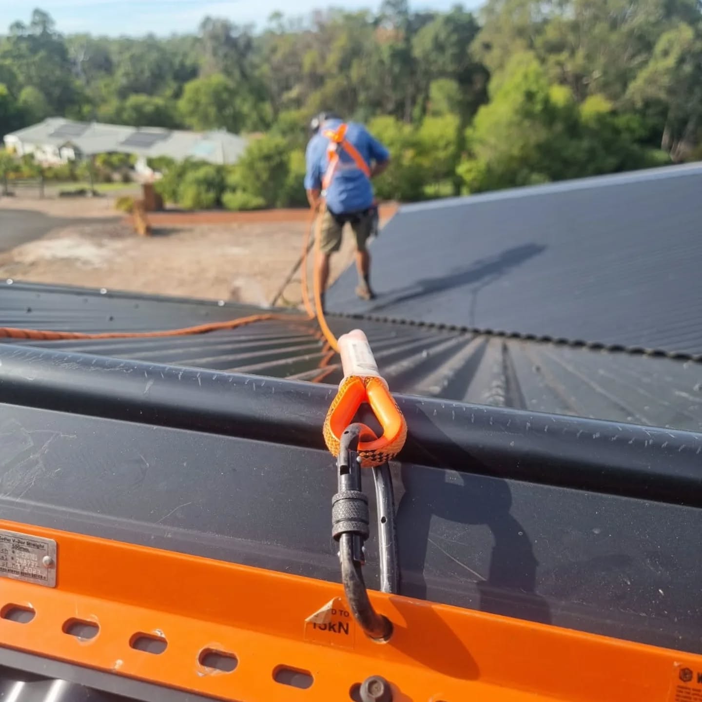Orange rope anchor and locking carabiner clipped to a roof rail